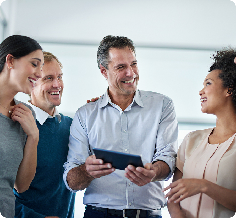 Diverse group of four JVRC professionals smiling and collaborating with tablet in contemporary office setting