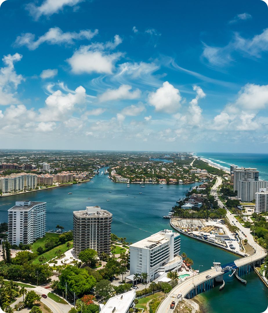 Boca Raton aerial panorama featuring oceanfront resorts, golf greens, and pink architecture for JVRC clients